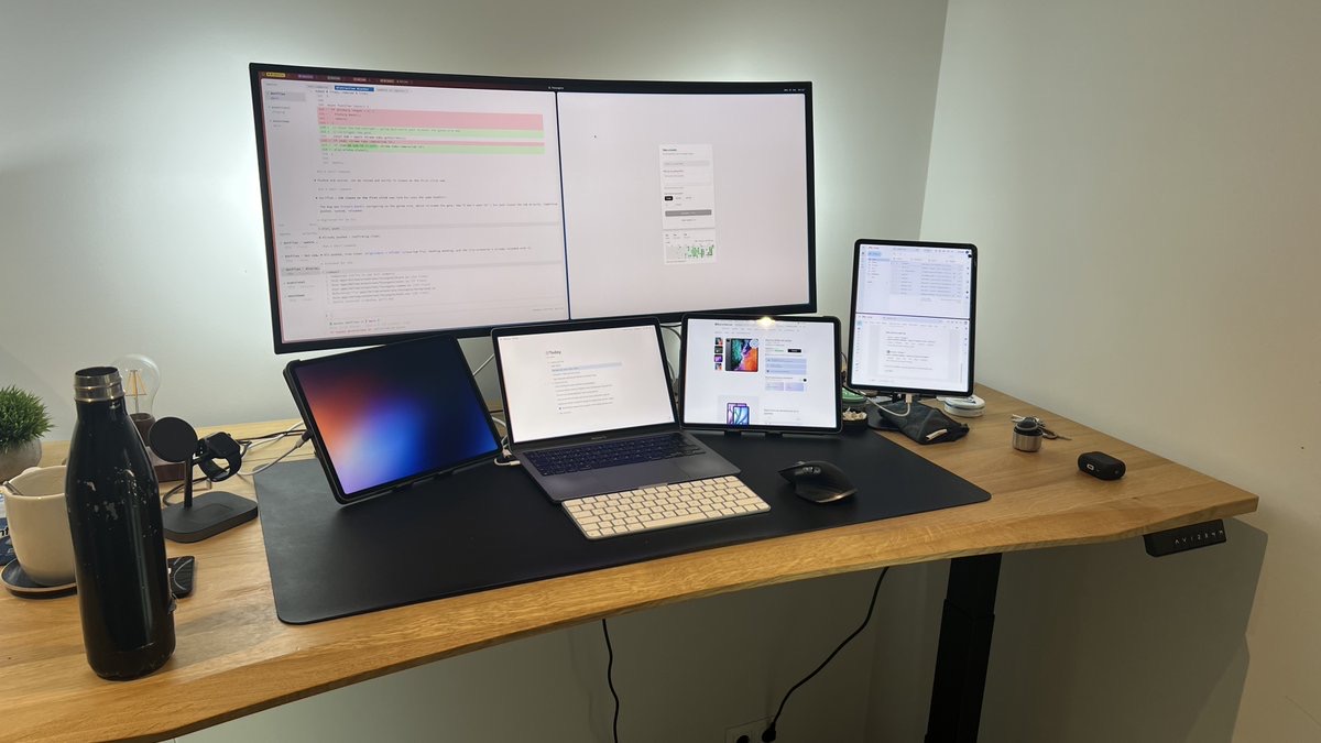Desk with an LG ultrawide, a MacBook Pro and three iPad Pros all running as displays